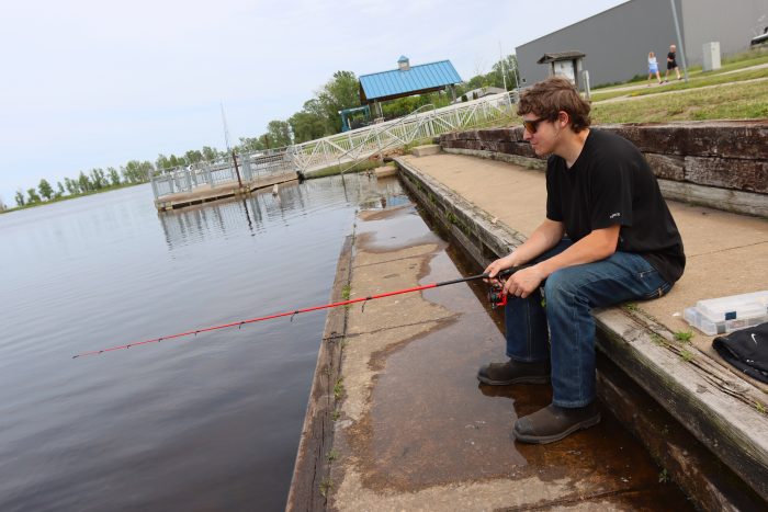 Guy Fishing On Red Arrow Pathway
