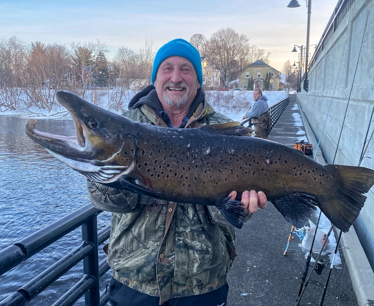 Man holding a large fish up to the camera in both hands.