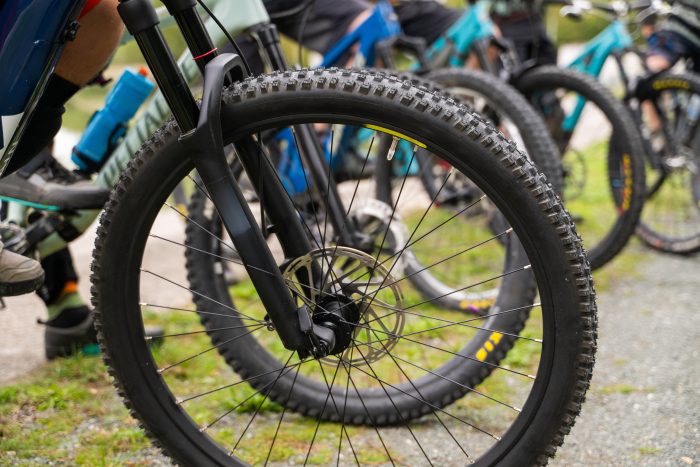 Close up image of a bike wheel with a line of bike wheels in the background
