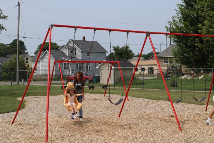 Mother pushing child on swin at Fred carney park in Marinette