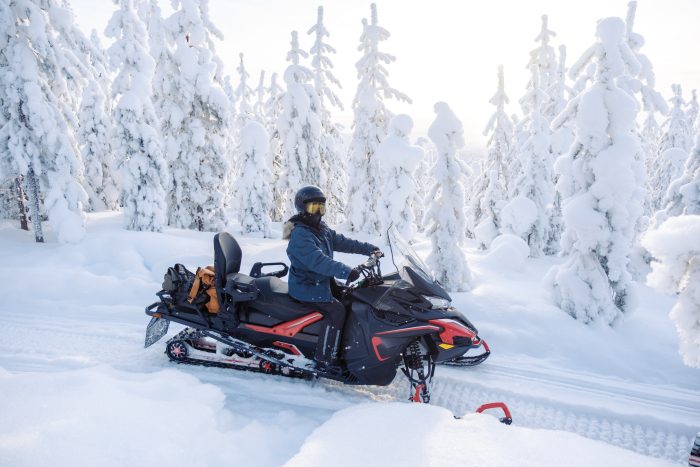 A person snowmobiling on a snowy trail